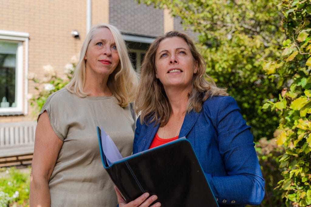 Martine van Engelenburg in gesprek met een klant bij een woning