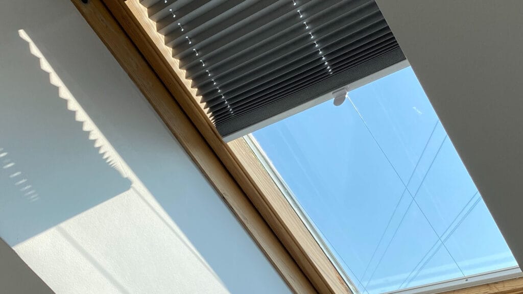 Dakraam met rolgordijn in een slaapkamer
