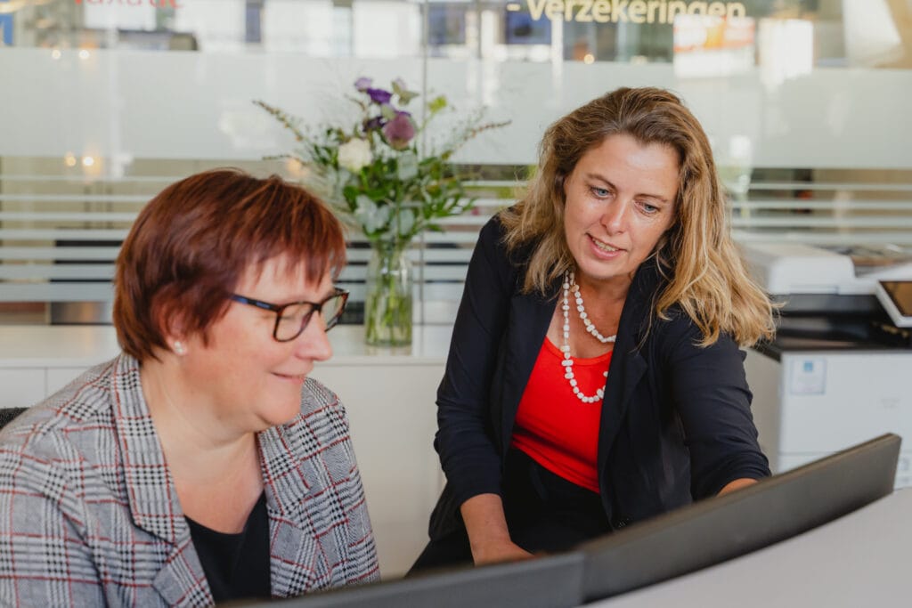 Martine van Engelenburg bespreekt de woningpresentatie met een klant achter de laptop