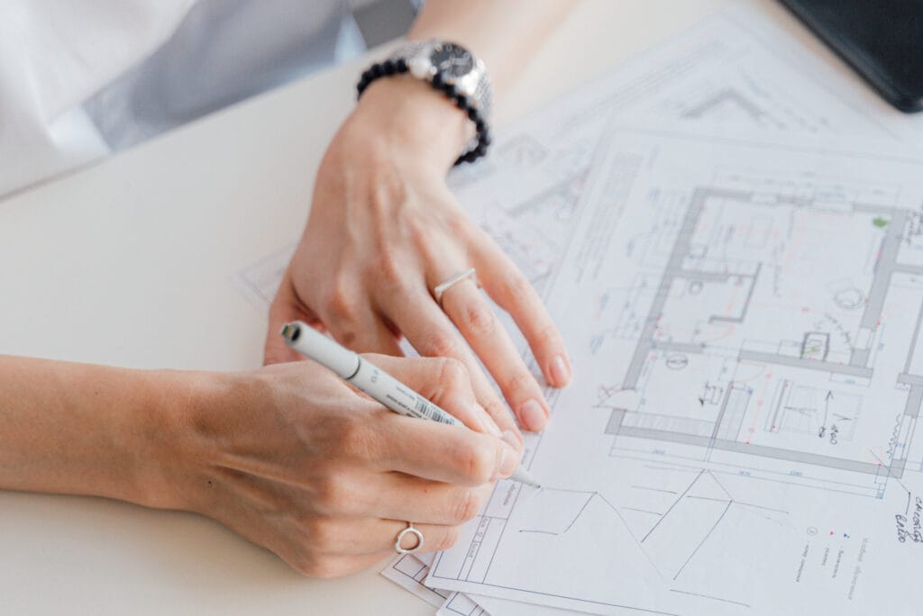 Hand met pen op een bouwtekening